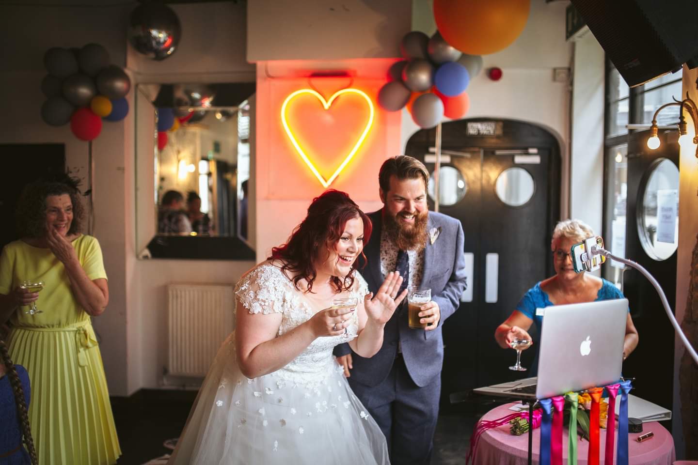Micro Wedding Bride and groom wave at their virtual guests on Zoom