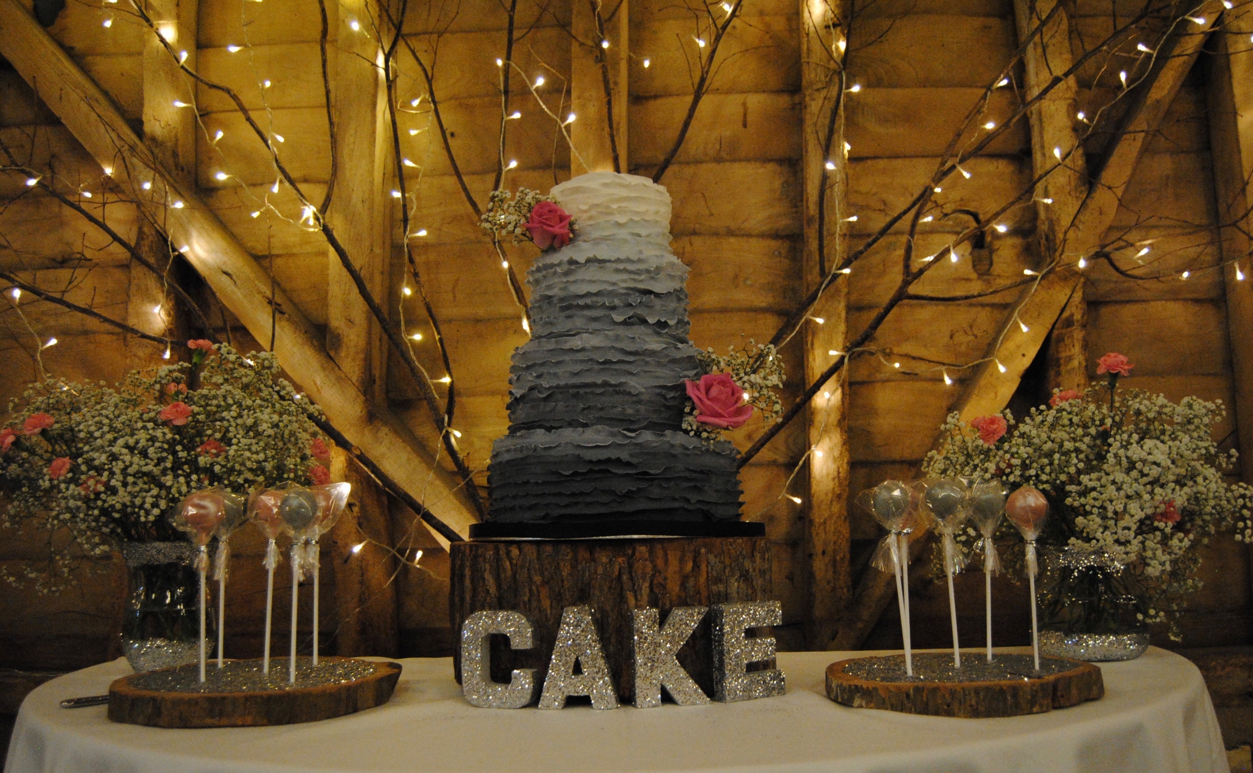 A grey and cream wedding cake on a piece of wood